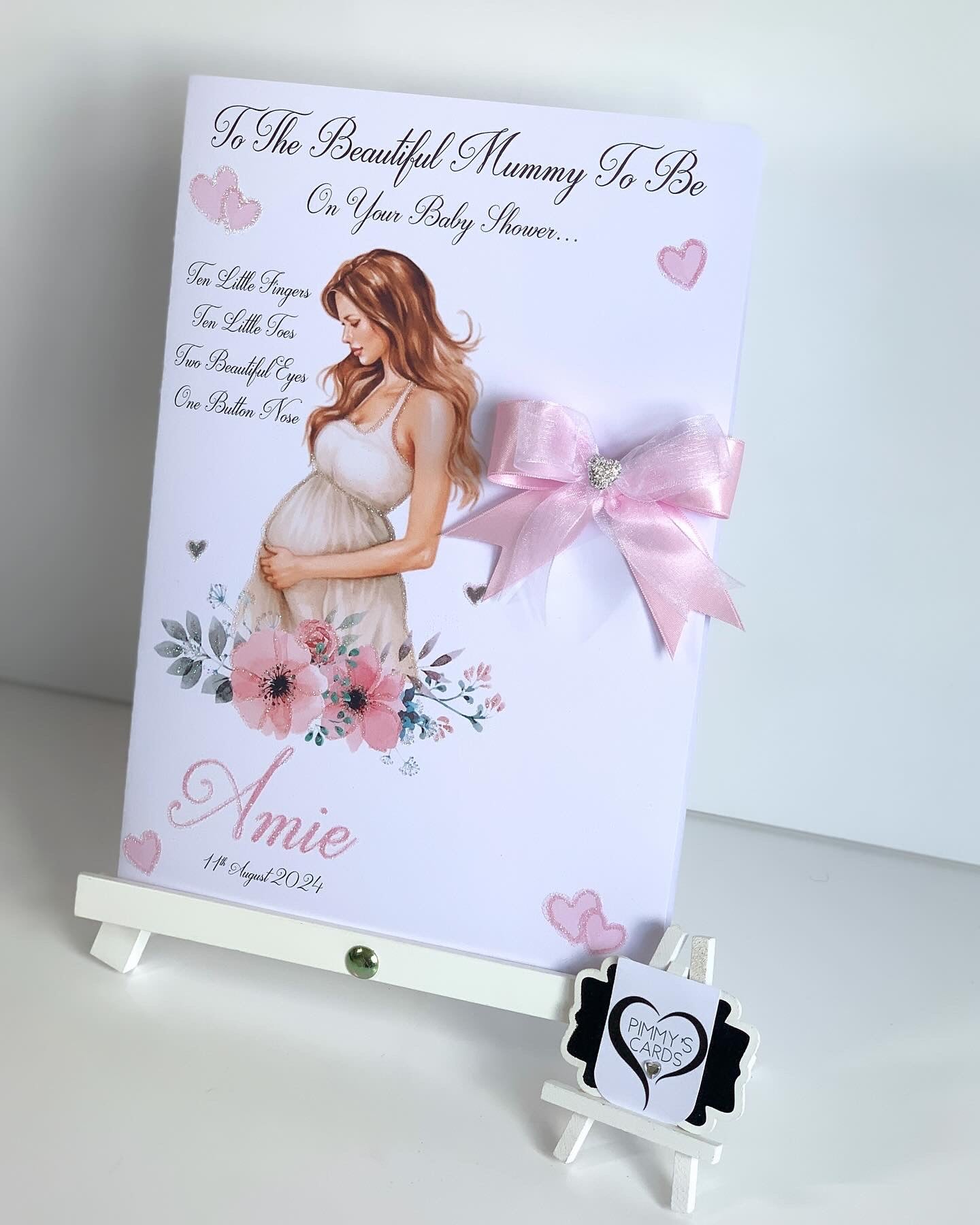 Baby shower card for a pregnant woman with floral design and pink bow on a white background