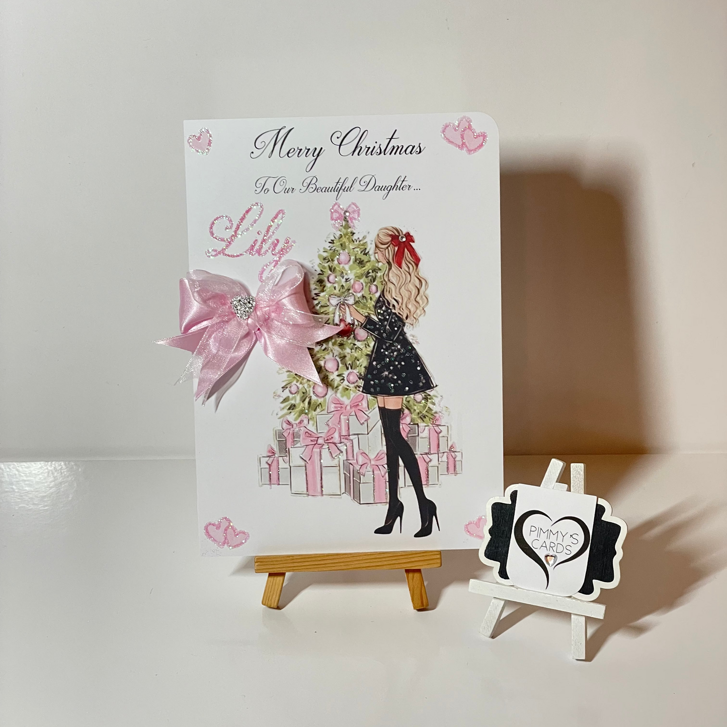 Pink Christmas personalised cards. Lady at Christmas tree with pink presents.