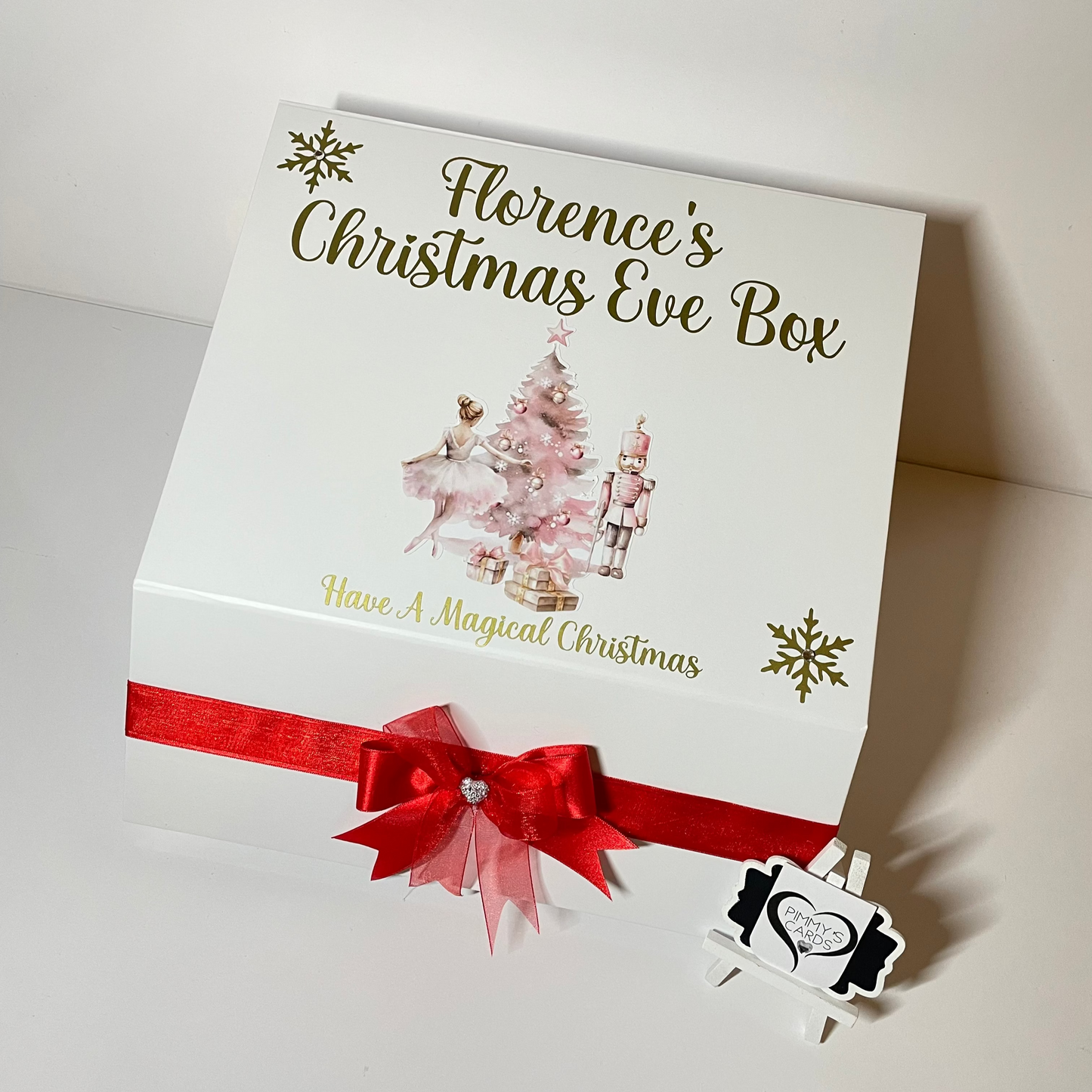 Personalised Christmas Eve box with festive design and red ribbon on a white background