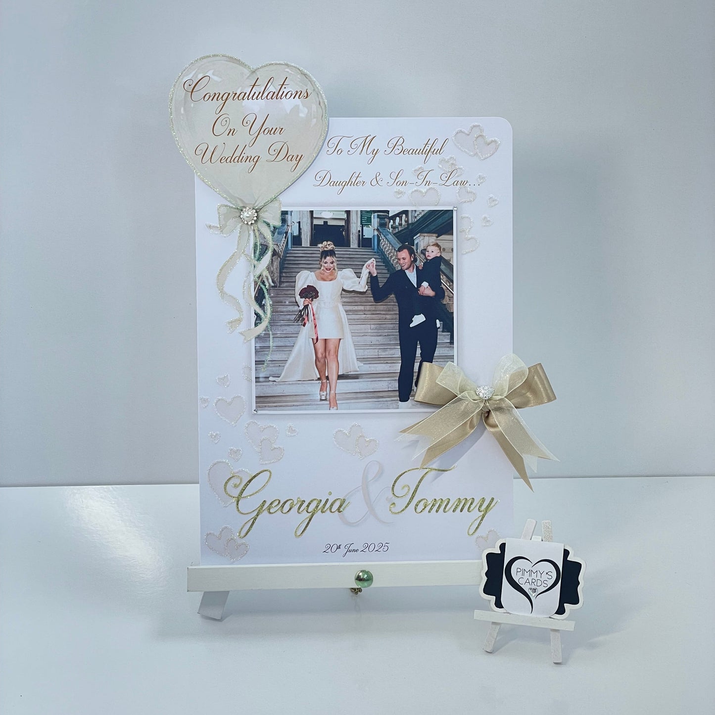 Personalised wedding photo card of Georgia Kousoulou & Tommy Mallet Gold theme with bow