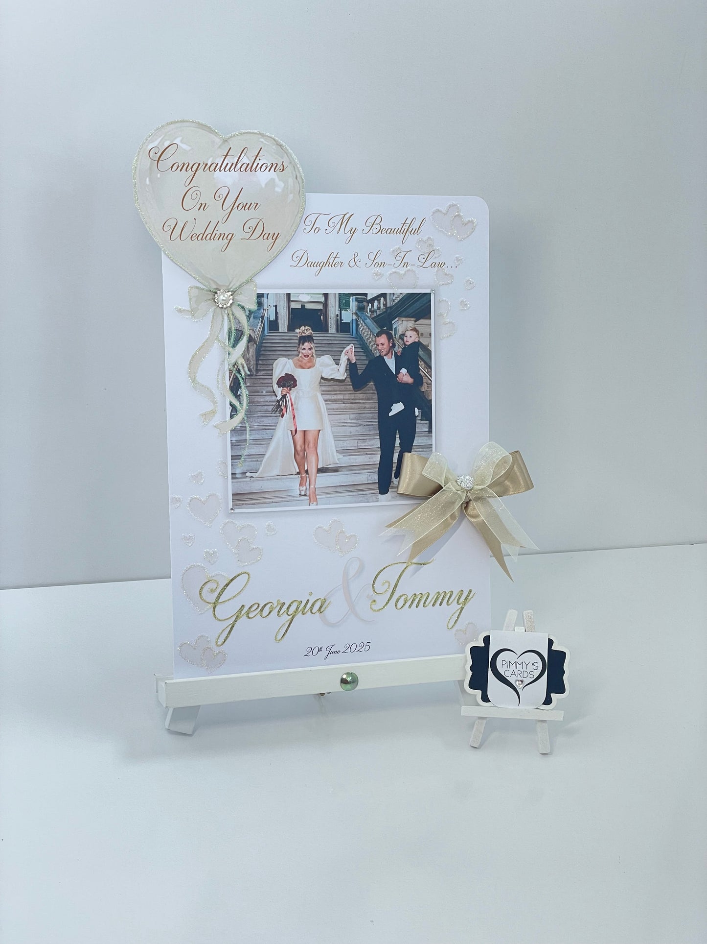 Personalised wedding photo card of Georgia Kousoulou & Tommy Mallet Gold theme with bow