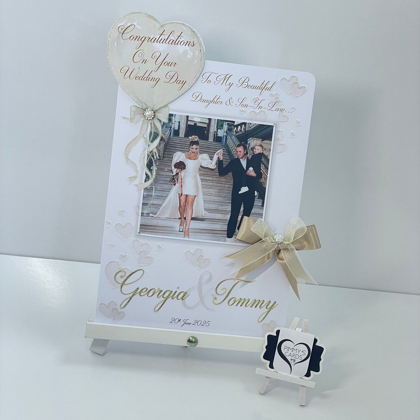 Personalised wedding photo card of Georgia Kousoulou & Tommy Mallet Gold theme with bow