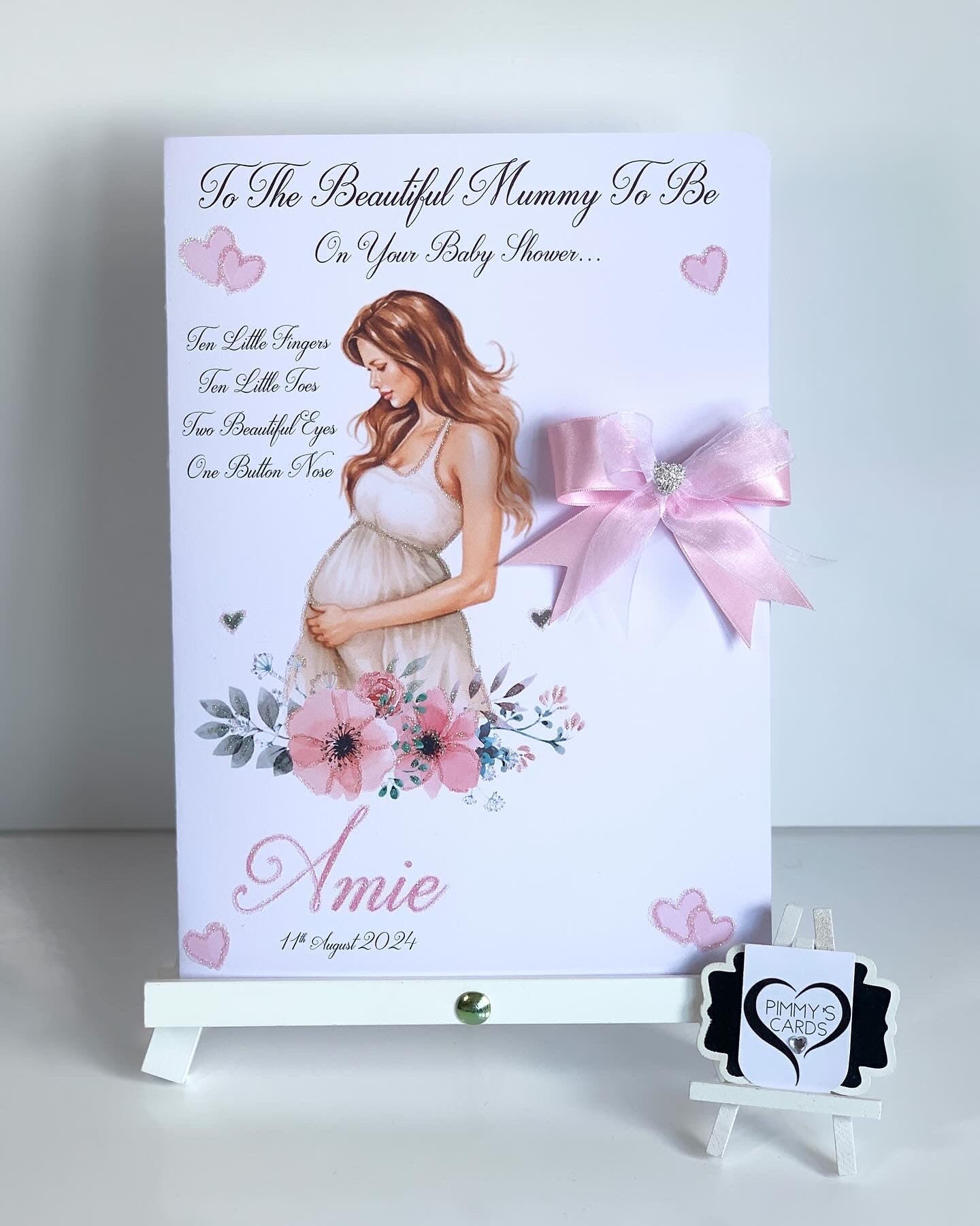 Baby shower card for a pregnant woman with floral design and pink bow on a white background