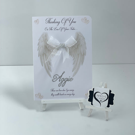 Memorial card with angel wing design and 'Thinking of You' message on a white background