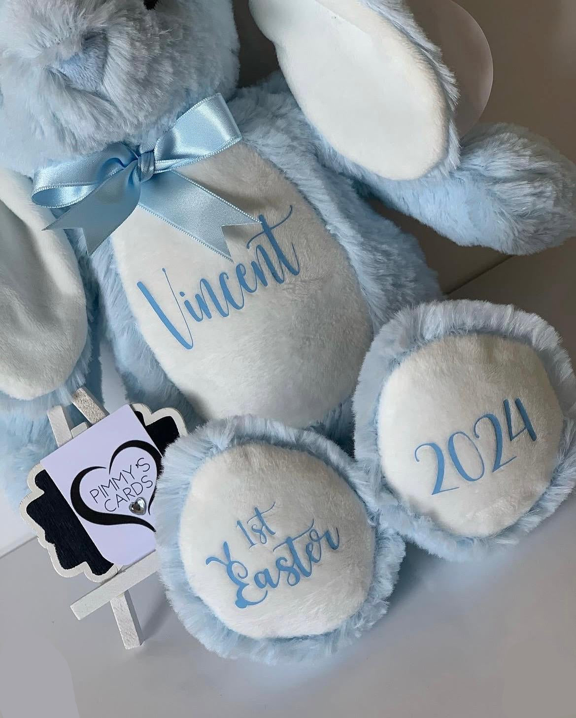 Blue plush bunny with personalised name and '1st Easter 2026' text on it. Personalised Soft Toy Bunny